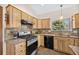 Well-equipped kitchen with stainless steel oven, granite counters, wooden cabinetry, and a window overlooking the outside at 459 Virginia Ave, Palmer Lake, CO 80133