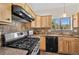 Bright kitchen with stainless steel oven, granite counters, wooden cabinetry, and a window with a view of the outdoors at 459 Virginia Ave, Palmer Lake, CO 80133