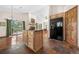 Open floor plan featuring a kitchen island, wood floors, vaulted ceilings, fireplace, and glass sliding doors to a balcony at 459 Virginia Ave, Palmer Lake, CO 80133