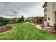 Large grassy backyard with manicured landscaping, patio, and backyard pergola at 15160 W Iliff Pl, Lakewood, CO 80228