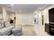 Finished basement with gray sofa, light wood-look flooring, and adjacent bathroom at 15160 W Iliff Pl, Lakewood, CO 80228