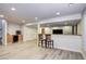 Finished basement featuring a bar with two chairs and light wood-look flooring at 15160 W Iliff Pl, Lakewood, CO 80228