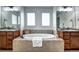 Luxurious bathroom featuring a soaking tub, dual vanities, and elegant fixtures, perfect for relaxation at 15160 W Iliff Pl, Lakewood, CO 80228
