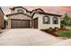 Beautiful home featuring a stone facade, brown trim and a spacious driveway and 3-car garage at 15160 W Iliff Pl, Lakewood, CO 80228