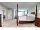 Spacious main bedroom with a four-poster bed, sitting area, and ample natural light, elegant and inviting at 15160 W Iliff Pl, Lakewood, CO 80228