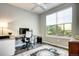 Bright office space featuring a modern desk setup and large window providing natural light and an area rug at 15160 W Iliff Pl, Lakewood, CO 80228
