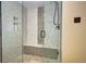 Modern tiled shower with glass door, mosaic accents, and built-in bench at 15160 W Iliff Pl, Lakewood, CO 80228