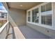 Covered outdoor balcony with light wood floors and large windows providing natural light at 5128 Preserve Pl, Firestone, CO 80504