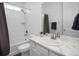 This bathroom features a shower-tub combo, a sink with a marble countertop, and white fixtures at 5128 Preserve Pl, Firestone, CO 80504