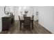 Dining room with dark wood table, hardwood floors, with ample natural light from the nearby window at 5128 Preserve Pl, Firestone, CO 80504
