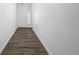 Clean hallway with wood floors and bright white walls, leading to the front door at 5128 Preserve Pl, Firestone, CO 80504
