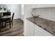 Close up of a kitchen with white cabinets and granite countertops next to a dining area at 5128 Preserve Pl, Firestone, CO 80504