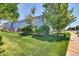 Exterior view of a home with a well-maintained lawn and fence, with mature trees providing shade at 165 Montgomery Dr, Erie, CO 80516