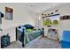 Comfortable bedroom featuring a large window for natural light, themed decorations, and neutral carpets at 165 Montgomery Dr, Erie, CO 80516