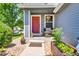 Inviting front porch with a red door, plants, and cozy seating, perfect for relaxing at 165 Montgomery Dr, Erie, CO 80516