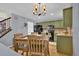 Spacious kitchen with green cabinets, black appliances, wood floors, and a cozy dining space at 165 Montgomery Dr, Erie, CO 80516