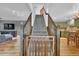 Bright, carpeted staircase with wooden railing and baby gate, connecting multiple levels of the home at 165 Montgomery Dr, Erie, CO 80516