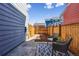 Private, fenced-in backyard with a small patio seating area and wood mulch landscaping creating a serene outdoor space at 5760 N Boston St, Denver, CO 80238