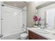 Bathroom features a tub with tiled walls, and a vanity with a sink at 5760 N Boston St, Denver, CO 80238