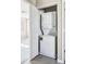 A white, stacked washer and dryer unit located in a closet with folding doors in the home's laundry area at 5760 N Boston St, Denver, CO 80238