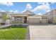 Beautiful home with a well-maintained lawn, stone accents, and a spacious three-car garage at 4723 Windmill Dr, Brighton, CO 80601