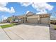 Inviting home exterior with stone accents, a spacious driveway, and lush green lawn at 4723 Windmill Dr, Brighton, CO 80601