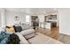 Open-concept living area with stylish furniture, modern decor, and hardwood floors at 4723 Windmill Dr, Brighton, CO 80601