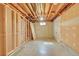 Unfinished basement space ready for customization, showcasing exposed beams and plumbing, with door and window framing at 6334 S Elati St, Littleton, CO 80120