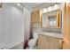 Well-lit bathroom with tiled shower/tub, granite countertop, and modern fixtures at 6334 S Elati St, Littleton, CO 80120