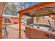 Backyard hot tub under a pergola with brick patio, grill, outdoor seating and privacy screen at 6334 S Elati St, Littleton, CO 80120
