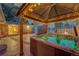 Illuminated hot tub and covered outdoor seating area for evening relaxation at 6334 S Elati St, Littleton, CO 80120
