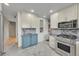 Stylish kitchen with stainless steel appliances, white cabinetry, and marble flooring at 6334 S Elati St, Littleton, CO 80120
