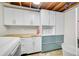 Well-organized laundry room showcasing ample storage cabinets, butcher block countertop, and modern washer and dryer at 6334 S Elati St, Littleton, CO 80120