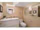 Well-lit bathroom featuring a modern vanity, round mirror, and tile backsplash at 7745 S Trenton Ct, Centennial, CO 80112