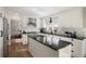 Bright kitchen with white cabinetry, granite counters, stainless appliances, and a large center island at 7745 S Trenton Ct, Centennial, CO 80112