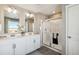 Bright bathroom features double vanity sinks, framed mirrors, and a glass enclosed shower at 18379 Field Mint Pt, Parker, CO 80134