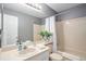 Bathroom features a tub, shower with white curtains, and a sink with cabinet storage at 5821 S Quatar Cir, Centennial, CO 80015
