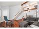 Spacious living room showcasing hardwood floors, a sectional sofa, and a staircase at 5821 S Quatar Cir, Centennial, CO 80015