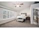 Spacious main bedroom with a large window, ceiling fan, ensuite bathroom, and bench at 5821 S Quatar Cir, Centennial, CO 80015