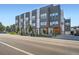 Modern townhome building with sleek gray and white exterior, large windows, and manicured landscaping at 1919 W 46Th Ave # 3, Denver, CO 80211