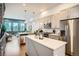 Well-lit kitchen with stainless steel appliances, a center island with quartz countertop, and open access to living area at 1919 W 46Th Ave # 3, Denver, CO 80211