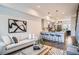 Open-concept living space with stylish decor, a modern kitchen featuring a breakfast bar, and hardwood floors at 1919 W 46Th Ave # 3, Denver, CO 80211
