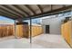 Covered patio, fenced backyard with storage shed and concrete parking area at 1440 S Logan St, Denver, CO 80210