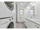 Modern bathroom equipped with stacked washer and dryer, glass shower and updated vanity at 1440 S Logan St, Denver, CO 80210