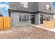 Updated duplex exterior with gray brick, wood fence, and gravel landscaping at 1440 S Logan St, Denver, CO 80210