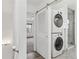 Efficient laundry area boasts a stacked washer and dryer, sliding door, and access to a shower at 1440 S Logan St, Denver, CO 80210