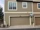 Townhouse exterior featuring a single-car garage, neutral siding, and white trimmed windows at 553 Hanging Rock Pl, Castle Rock, CO 80108