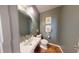 Charming powder room featuring a pedestal sink, decorative mirror, and tasteful wall art at 553 Hanging Rock Pl, Castle Rock, CO 80108