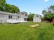Backyard featuring a deck, shed, grass, trees, a wooden fence, and light-gray houses at 4858 S Quintero Cir, Aurora, CO 80015