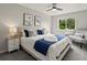 Bright bedroom featuring a queen bed with decorative pillows and a window overlooking a lush yard at 4858 S Quintero Cir, Aurora, CO 80015